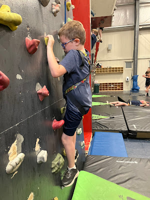 MOBALE athlete scaling a climbing route with instructor support